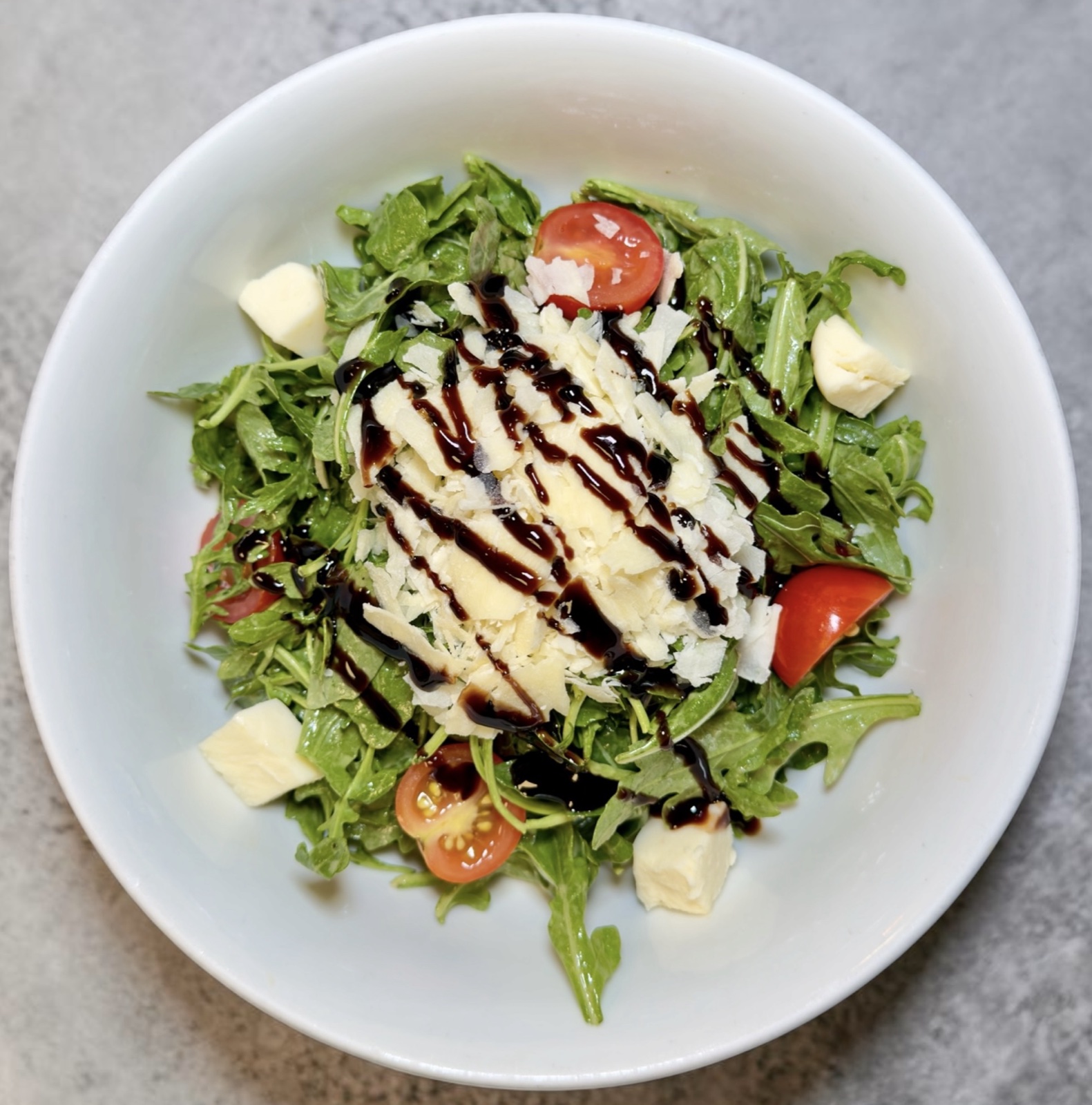 Arugola salad with cherry tomatoes, pearl mozzarella, and balsamic