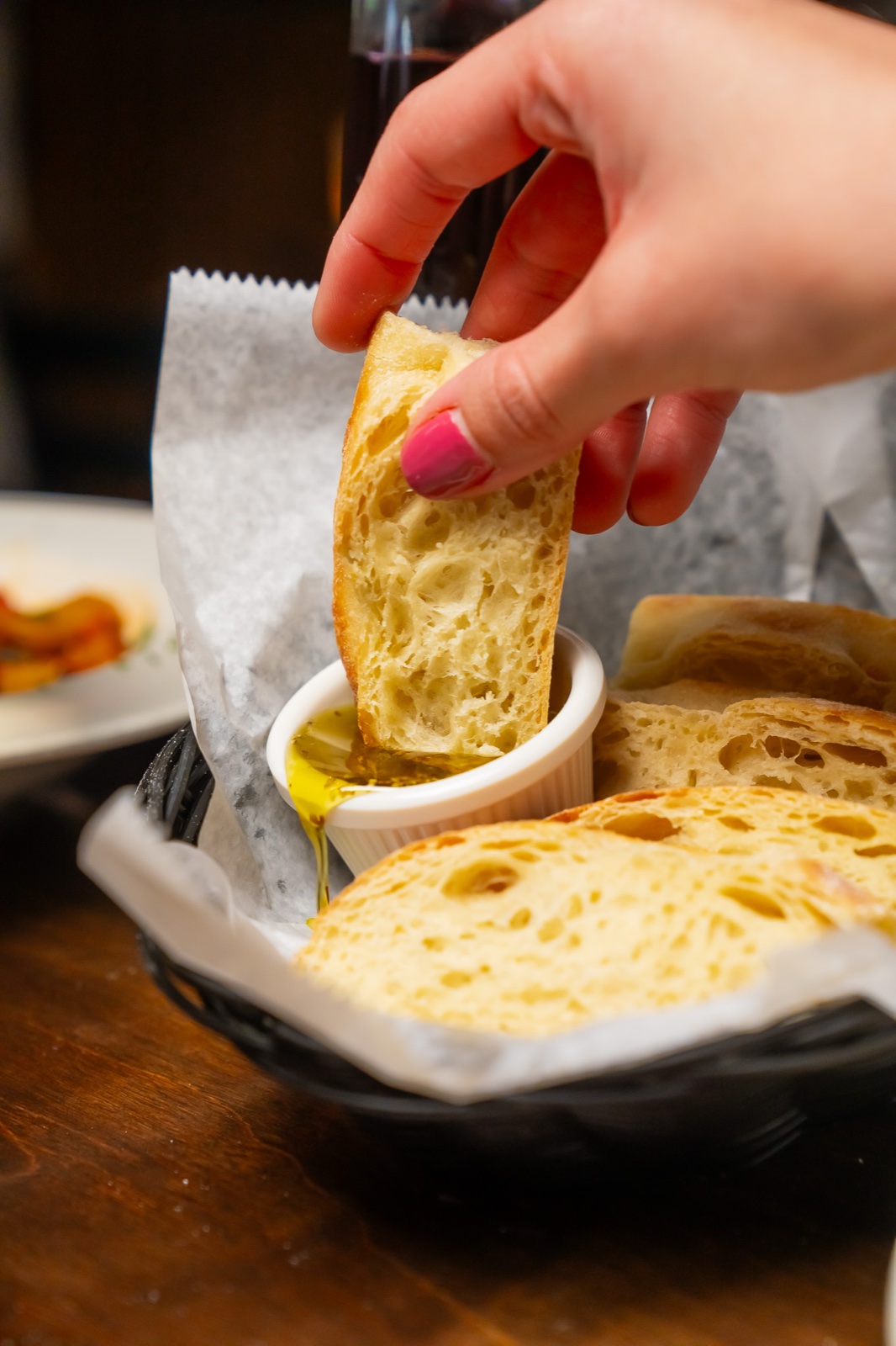 Crusty bread being dipped in olive oil at Sophia's