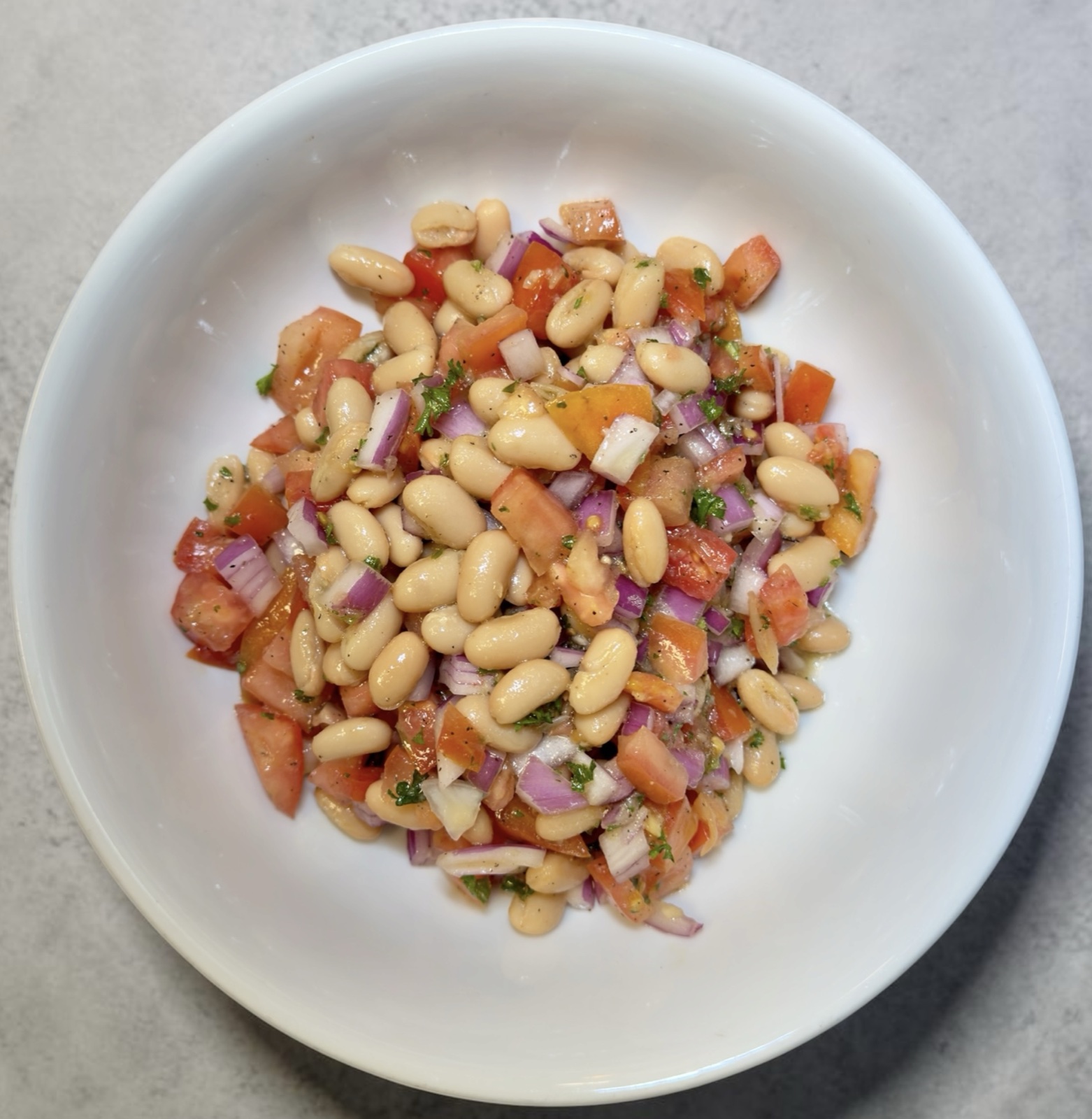 Cannellini beans salad with red onion, tomatoes, and citrus vinaigrette