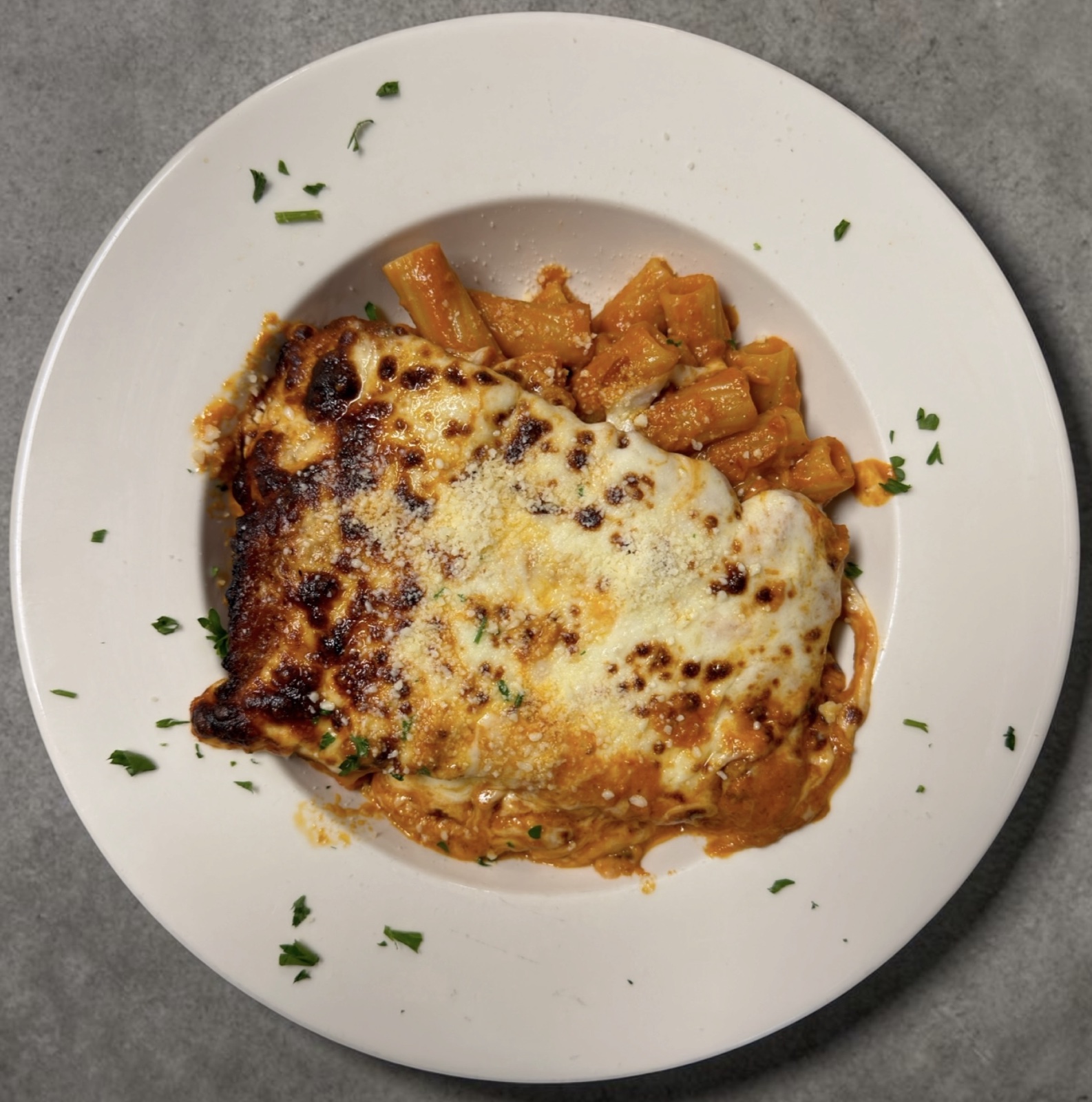 Chicken parmigiana in vodka sauce over rigatoni