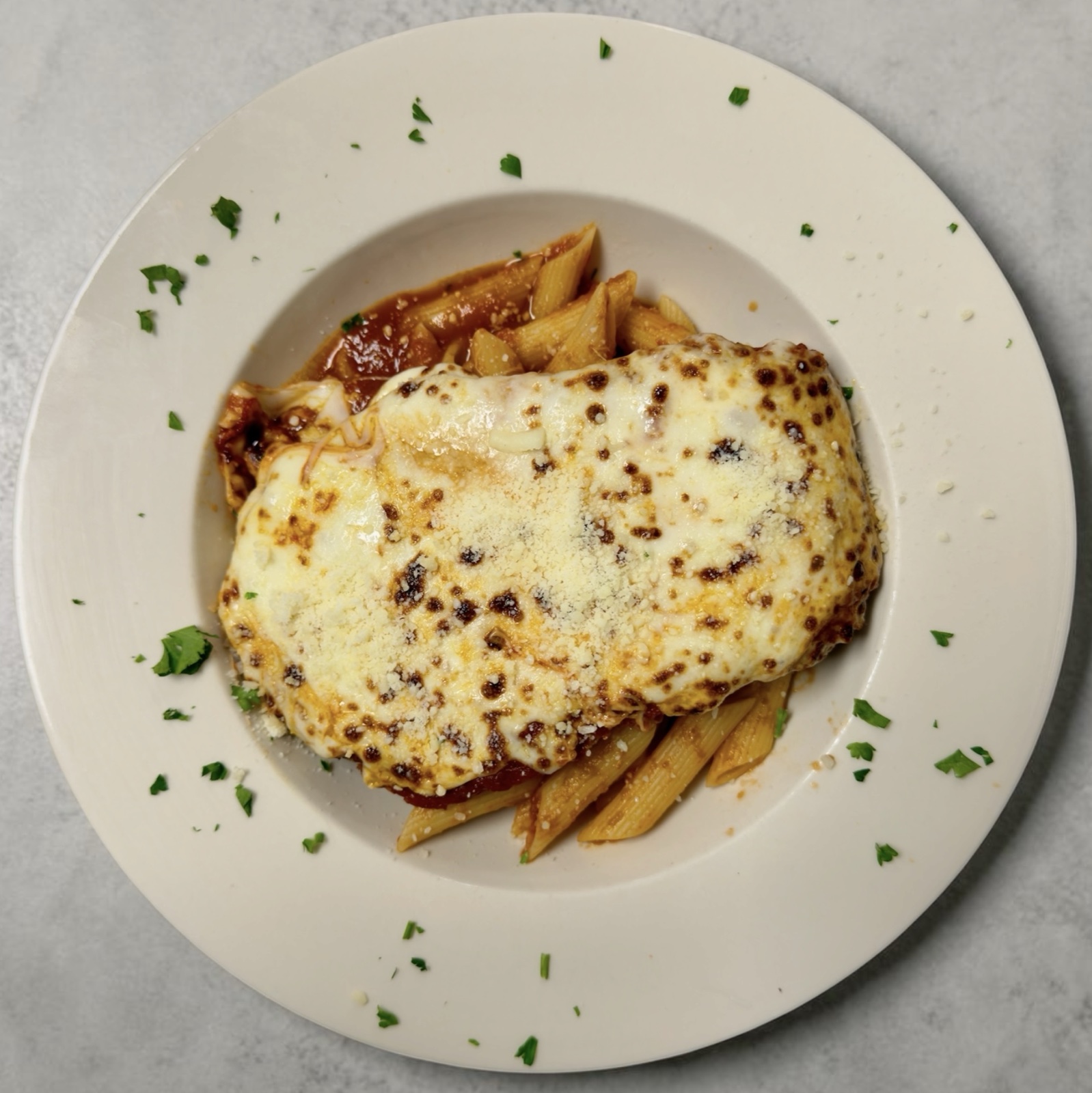 Chicken parmigiana with marinara, mozzarella, and Parmigiano Reggiano