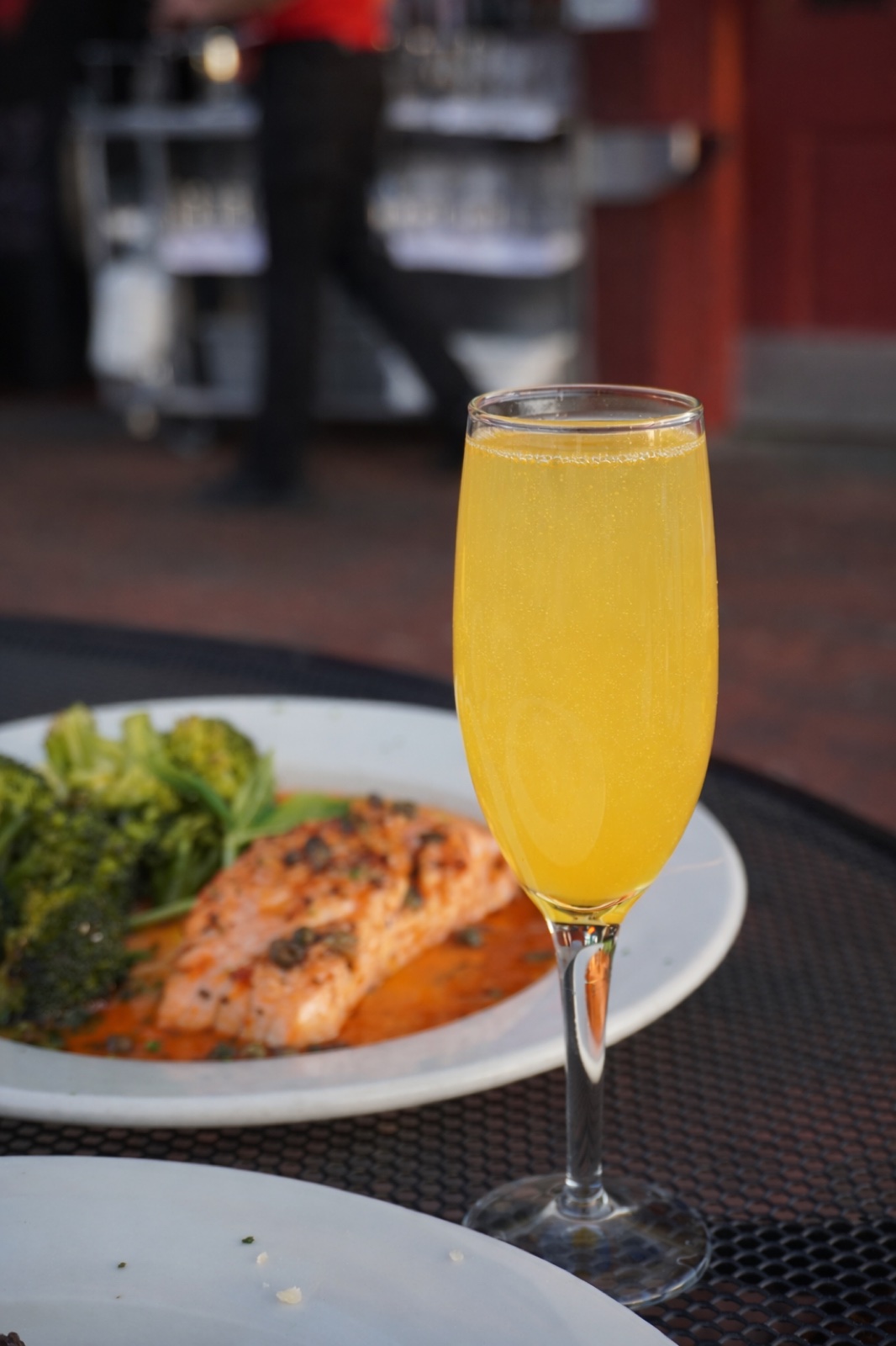 A mimosa next to a salmon entrée on Sophia's patio