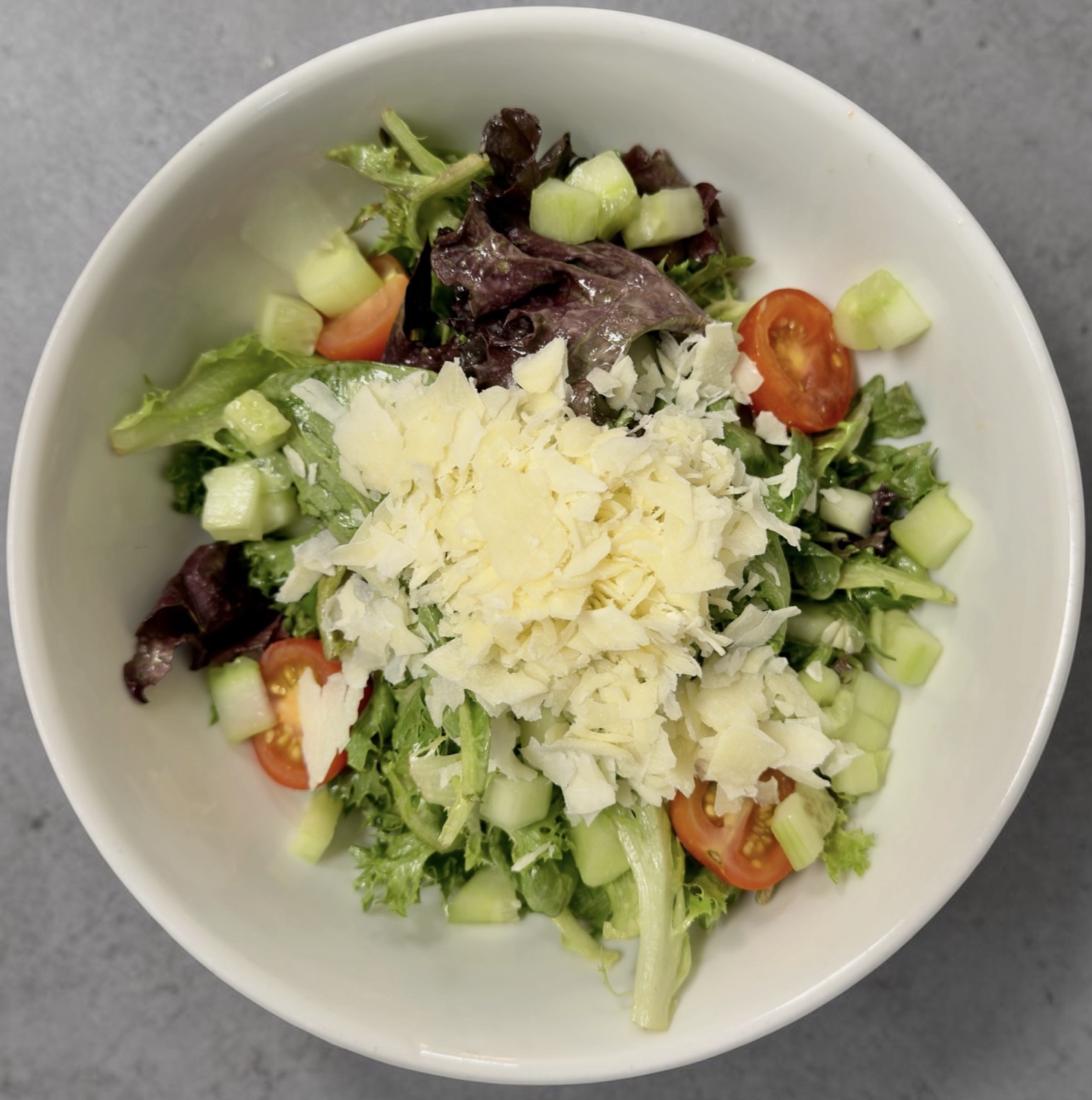 Mixed green salad with tomatoes, cucumbers, and balsamic